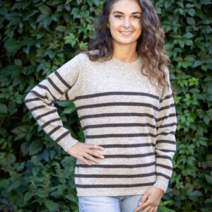 Jeune femme en promenade automnale avec le Pull Clun marron burel, écharpe légère et jean brut.