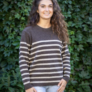 Femme portant le Pull Clun beige Kascha à rayures marron, assise en terrasse, style décontracté chic.