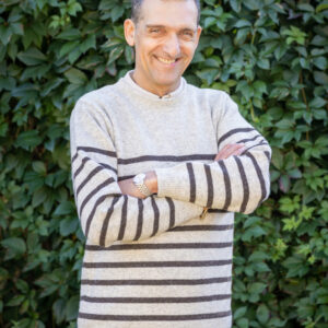 Homme portant le Pull Clun marron burel rayé beige, en balade à la campagne.